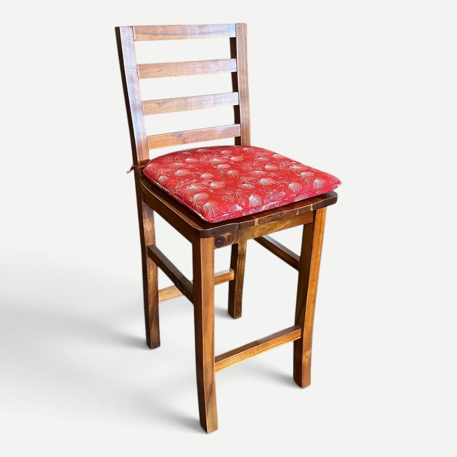 Hawaiian Discovery Furniture red polyester chair pad with floral pattern on a wooden Haleiwa dining chair