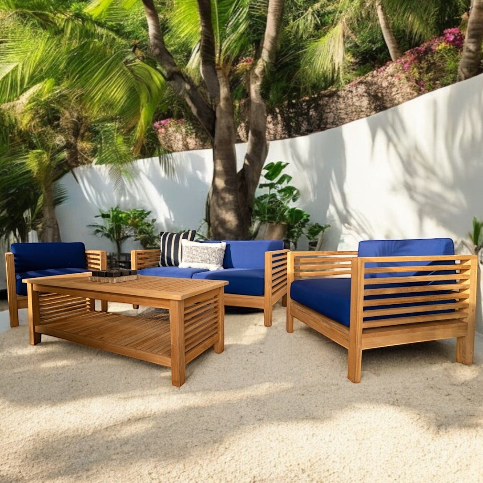 Hawaiian Discovery Furniture Summer teak wood outdoor loveseat set with blue cushions on a sandy patio
