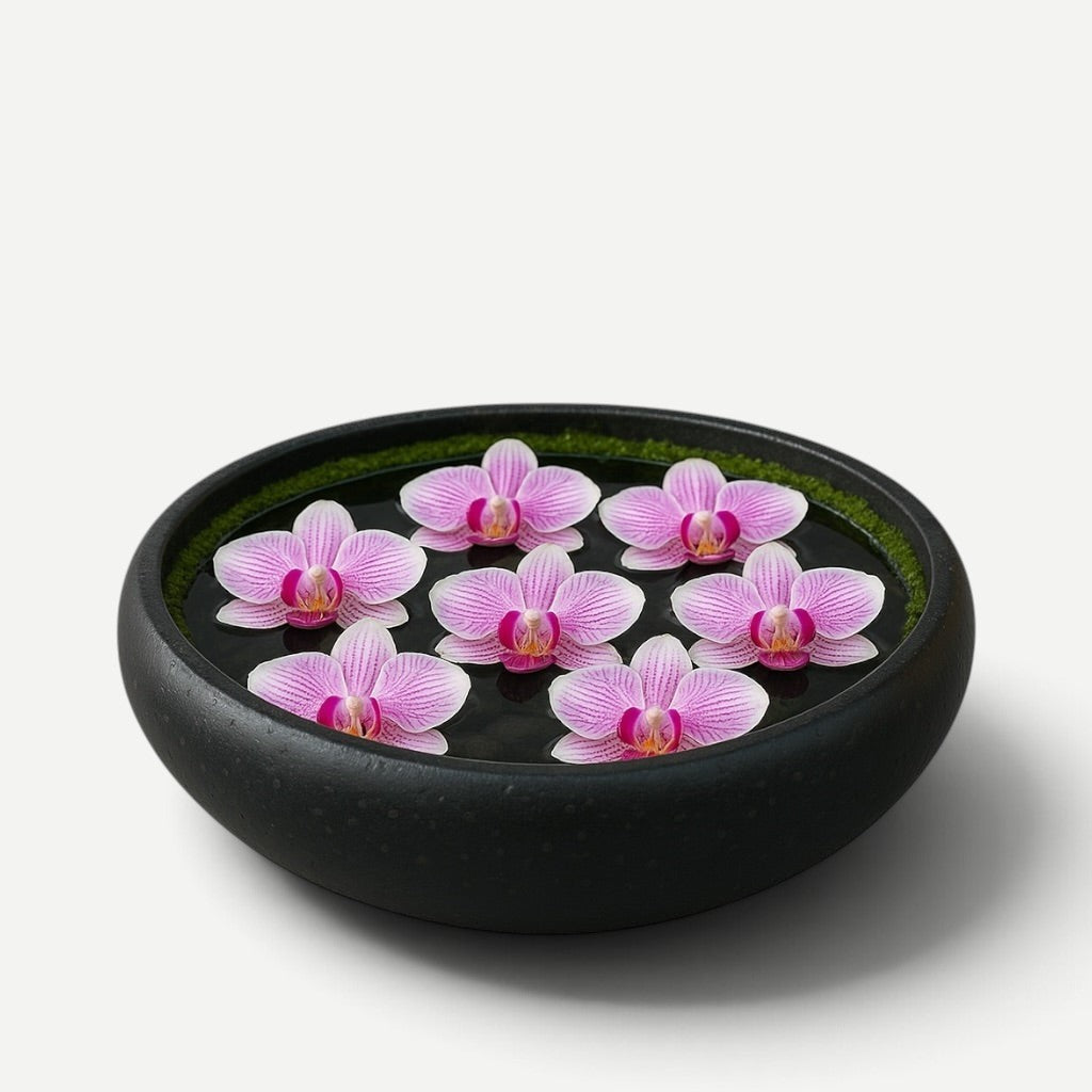 Hawaiian Discovery Furniture Calabash terrazzo bowl filled with water and floating pink orchid blossoms