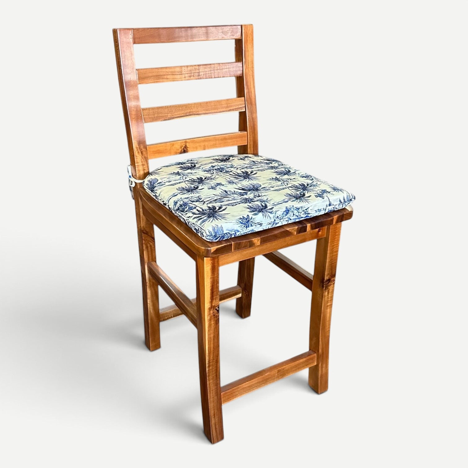 Hawaiian Discovery Furniture chair pad with blue and white tropical pattern on a wooden Haleiwa dining chair