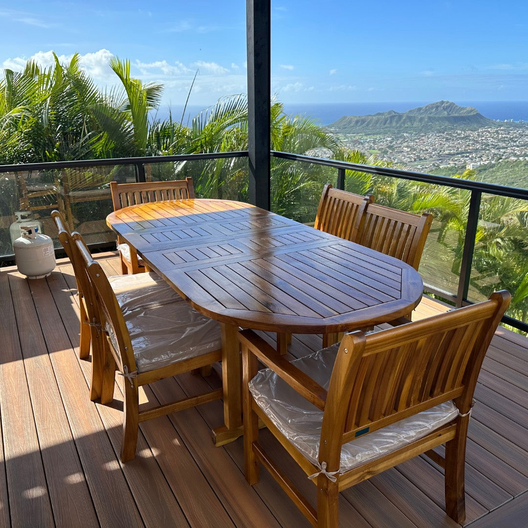 Hawaiian Discovery Furniture oval acacia wood extension table with matching chairs on a scenic outdoor deck