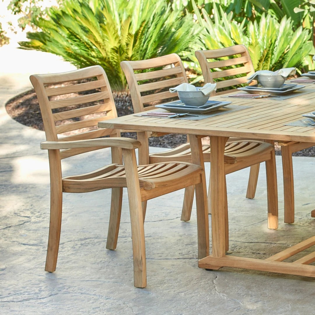 Hawaiian Discovery Furniture Birmingham stacking armchair in natural premium teak wood with curved slats on a patio