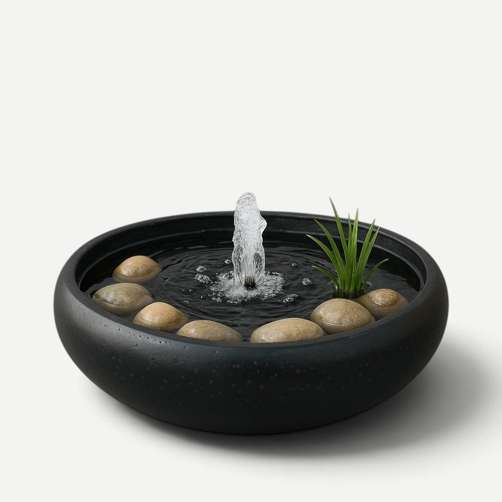 Hawaiian Discovery Furniture Calabash terrazzo planter bowl used as a tabletop water fountain with stones and greenery.
