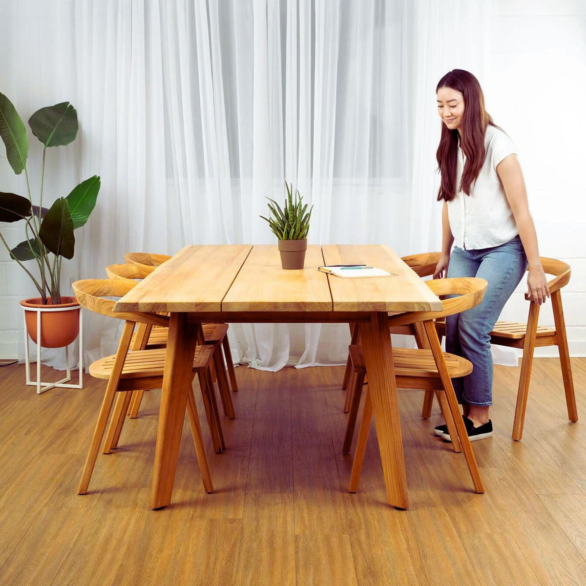 Hawaiian Discovery Furniture La Costa teak dining table with angled legs and matching chairs in a bright room