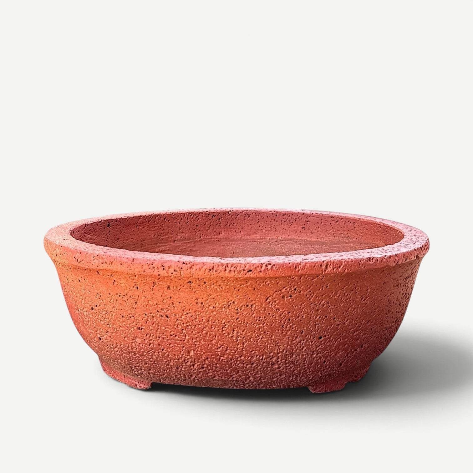 Hawaiian Discovery Furniture Kumo oval bonsai planter in terracotta red with a textured lightweight concrete finish.