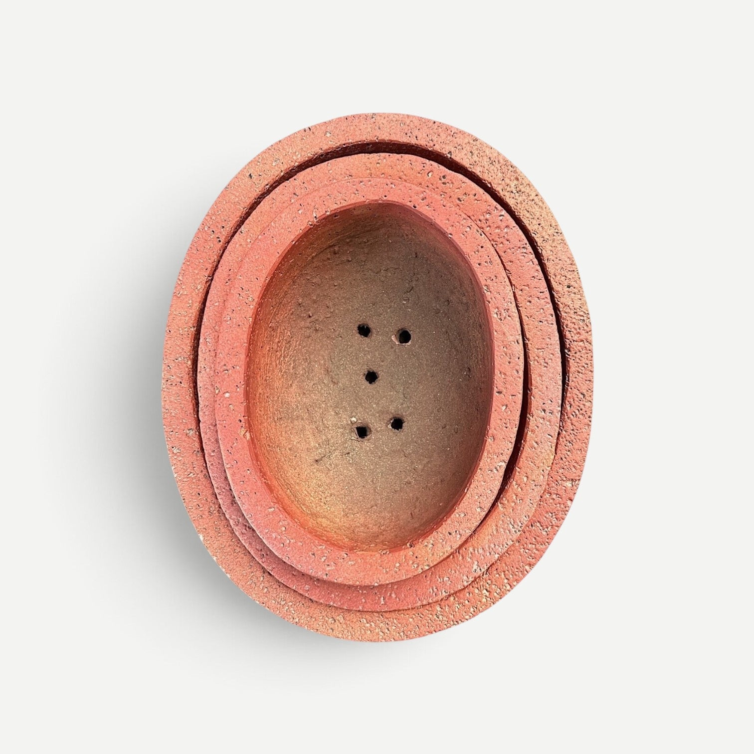 Hawaiian Discovery Furniture Kumo oval bonsai planter made of lightweight concrete and recycled foam in terracotta red.