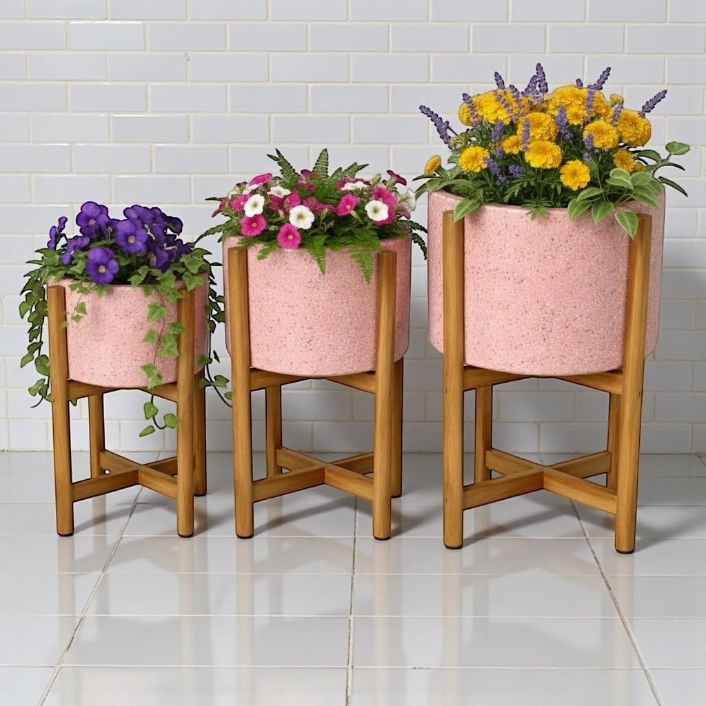 Hawaiian Discovery Furniture pink terrazzo planters in three sizes with acacia wood stands and colorful flowers.