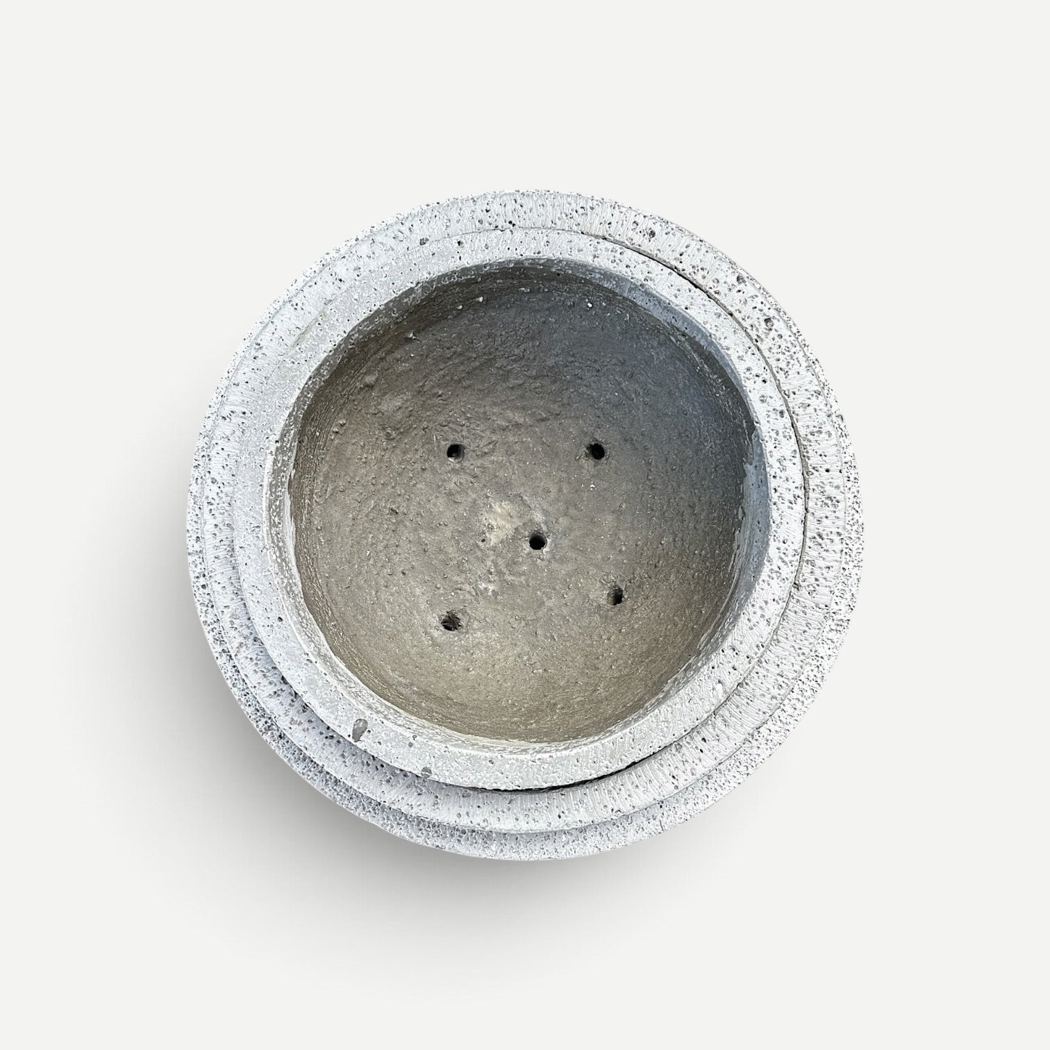 Hawaiian Discovery Furniture round bonsai planter in grey concrete and recycled foam with drainage holes, top view.