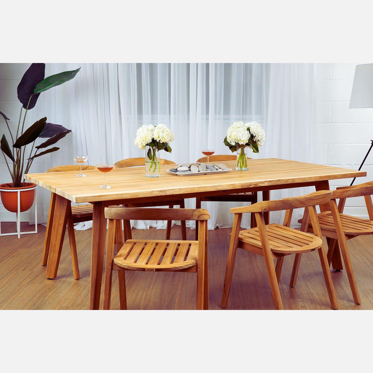 Hawaiian Discovery Furniture La Costa teak dining table with matching chairs set in a bright indoor dining room