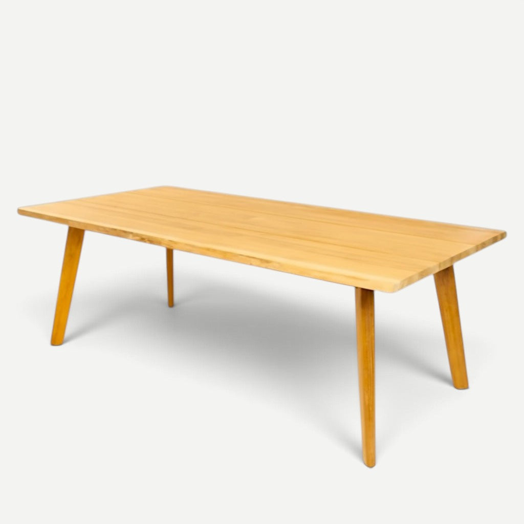 Hawaiian Discovery Furniture La Costa teak outdoor dining table with a wide rectangular plank top and angled legs.