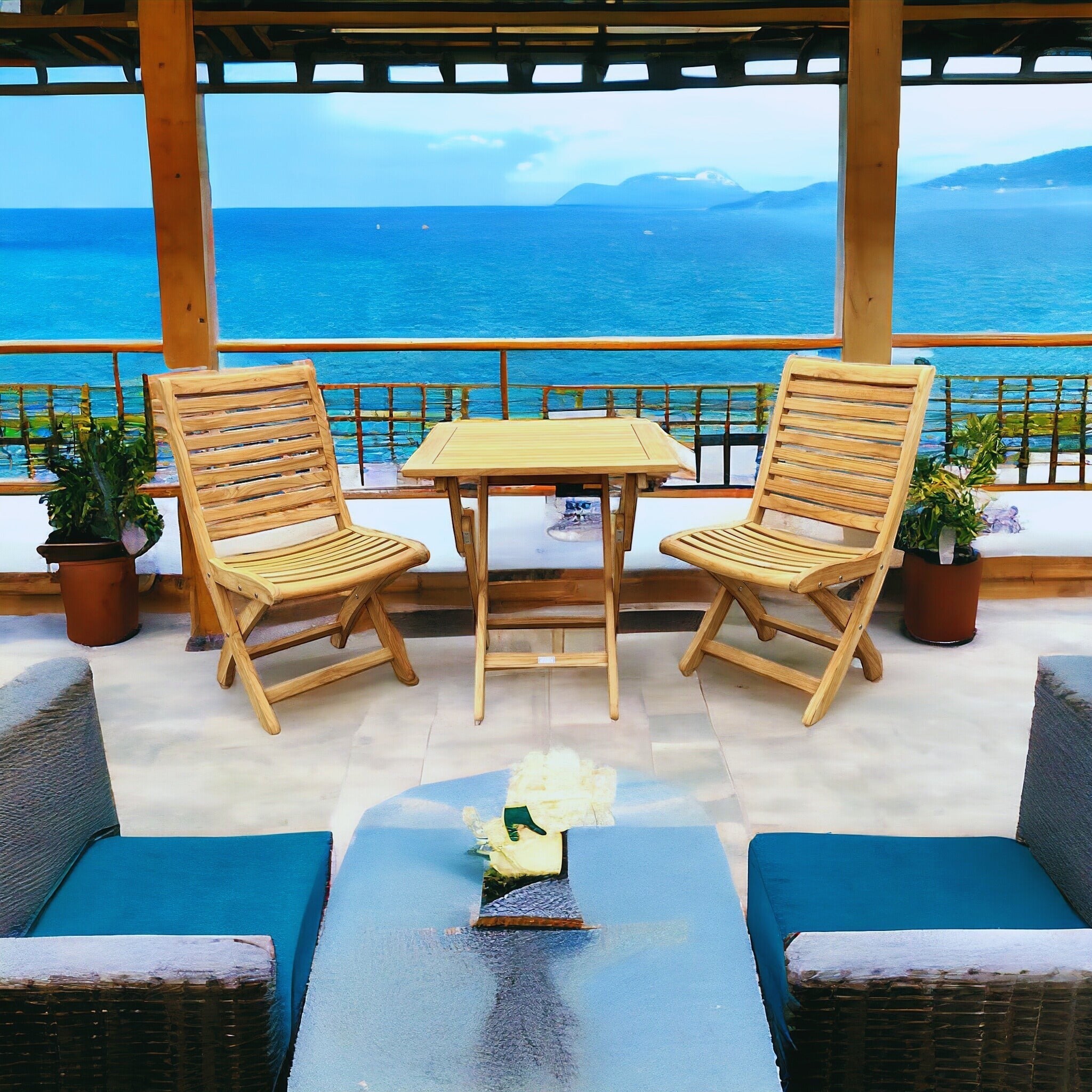 Hawaiian Discovery Furniture Kakahiaka teak set with two folding chairs and a square table on an oceanfront balcony.