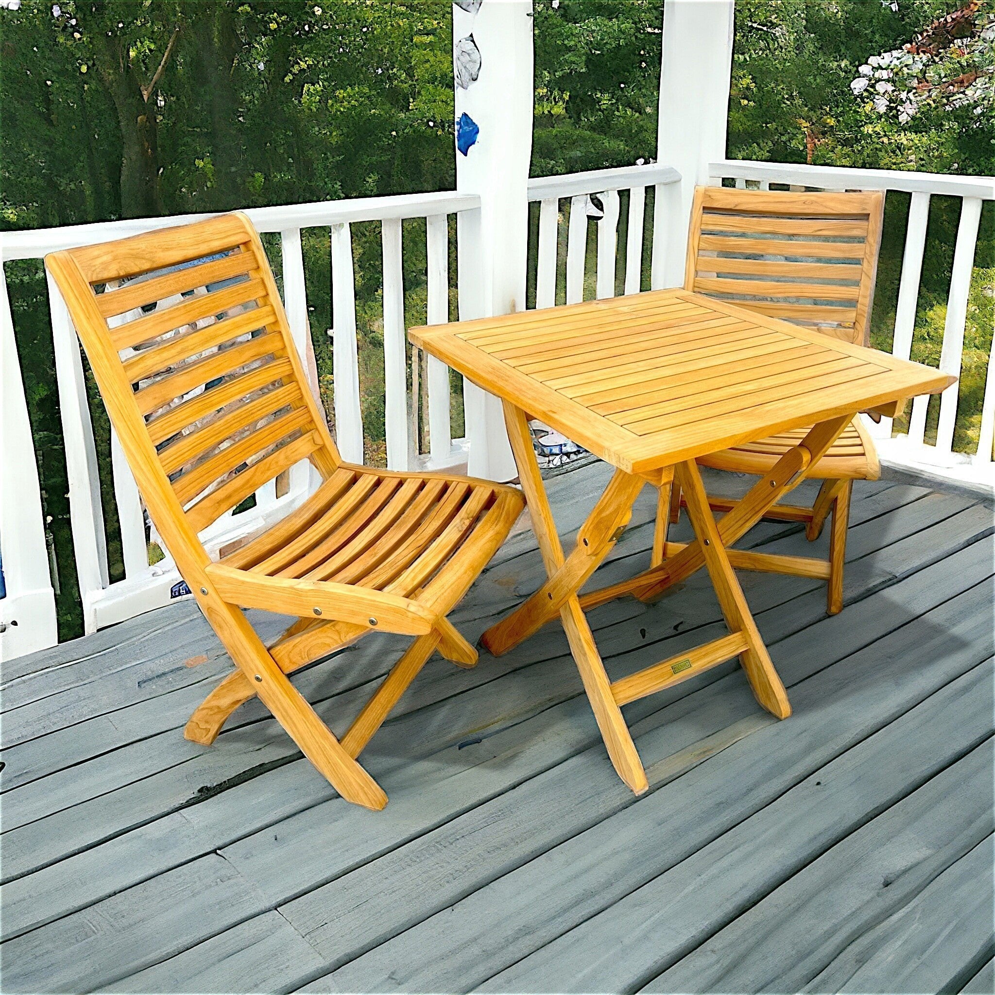 Hawaiian Discovery Furniture Kakahiaka set featuring two teak folding chairs and a square folding table on a deck.